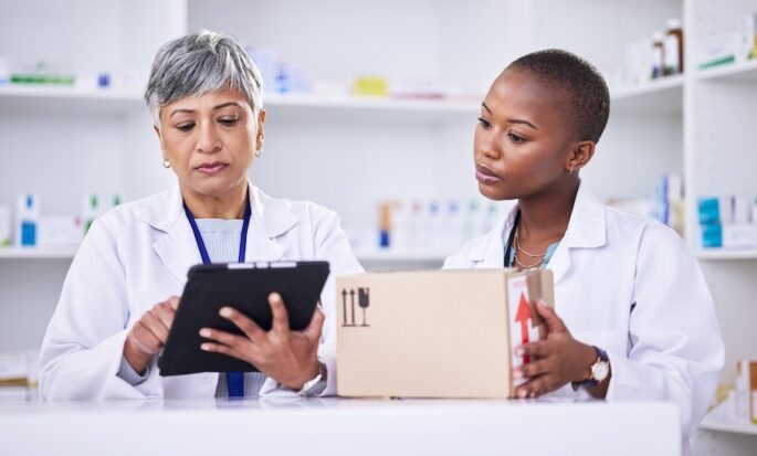 Woman, pharmacist and team with tablet or box in logistics for inventory inspection or stock at pharmacy. Medical or healthcare women with technology for supply chain, checklist or pharmaceuticals