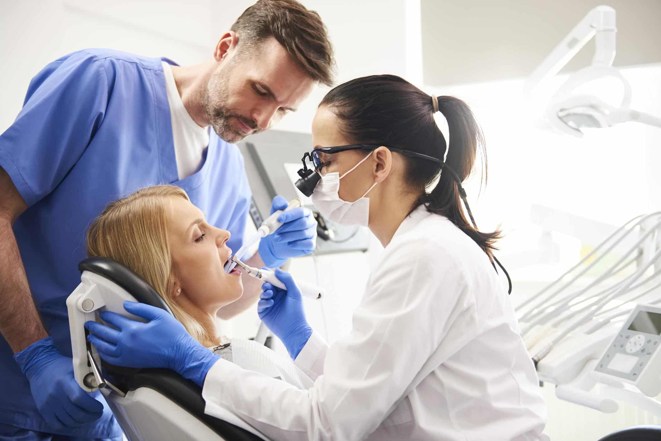 Dentist And Her Assistant Doing Their Work In Dentist's Clinic