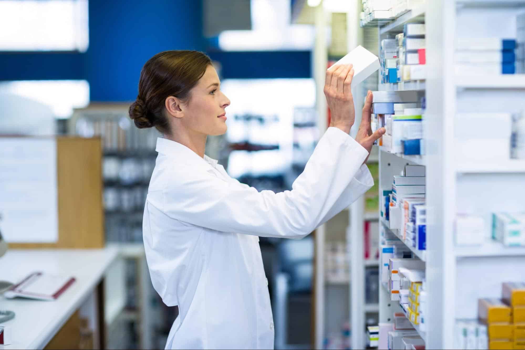 woman pharmacist stocking shelves